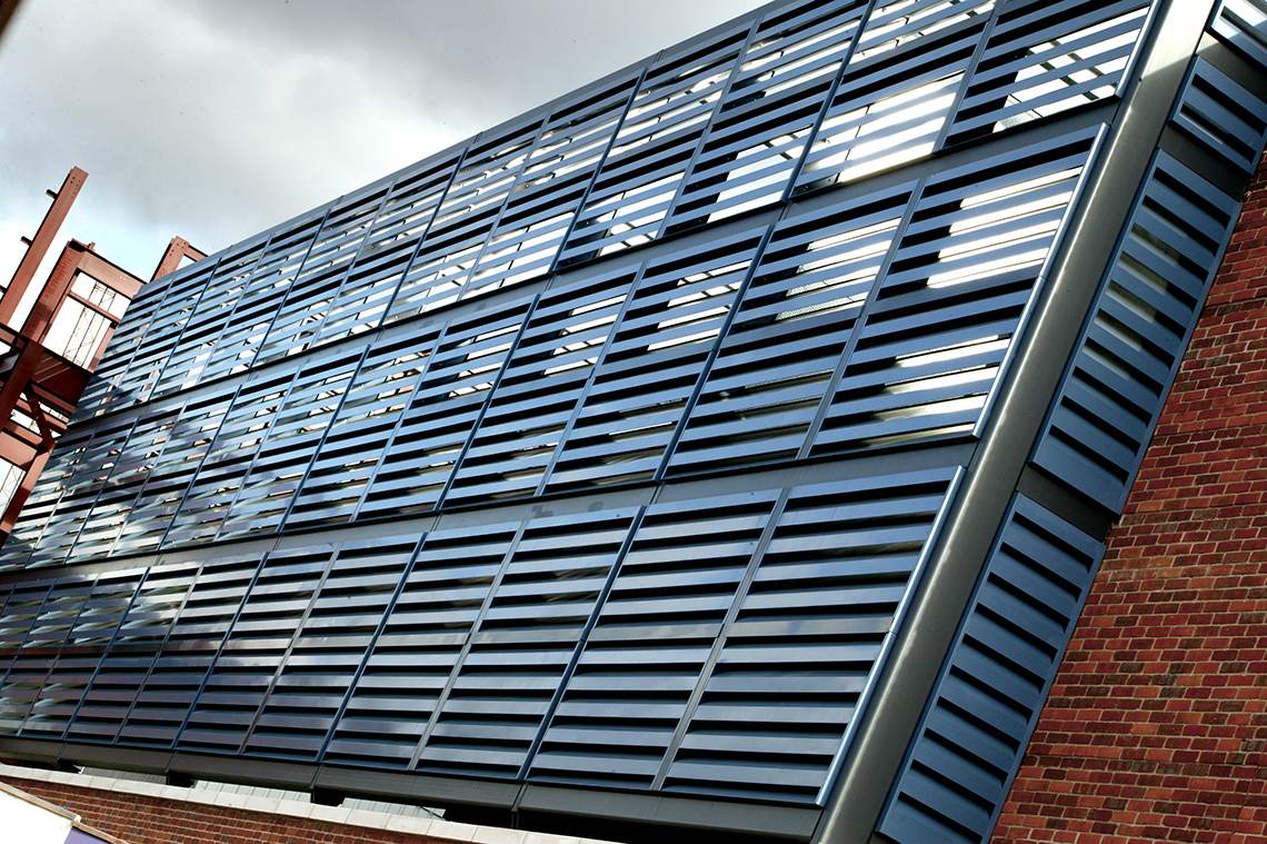 Akustisk facadebeklædning med IAC Acoustic Louvers der dæmper støj, opsat ved et parkeringshus.